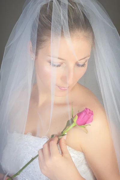 Bruid poseren in trouwjurk en roos — Stockfoto