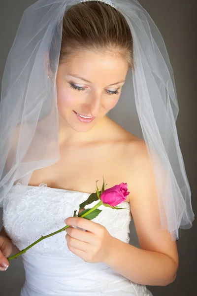 Noiva posando em vestido de noiva e rosa — Fotografia de Stock