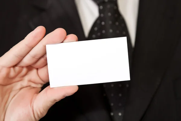 Деловой человек держит чистую карточку на белом изолированном фоне — стоковое фото