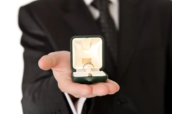 Homem de terno segurando anel de noivado no fundo isolado branco — Fotografia de Stock