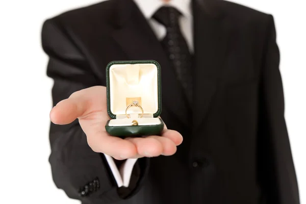 Mann im Anzug hält Verlobungsring auf weißem Hintergrund — Stockfoto