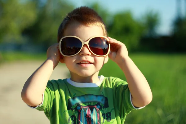Niño en gafas de sol y verano soleado Imagen de stock