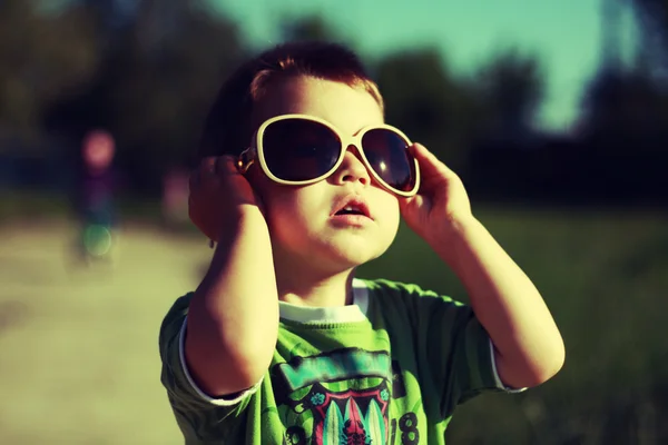 Niño en gafas de sol con estilo. Colores ricos Imágenes de stock libres de derechos