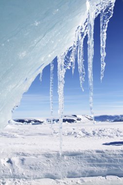 Ice hanging from an edge of an iceberg clipart