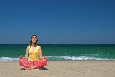 Woman making yoga in the bach clipart