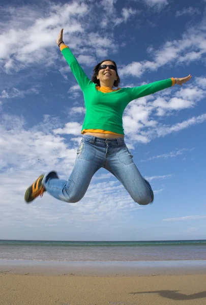 Jovem bela mulher fazendo um grande salto na praia — Fotografia de Stock