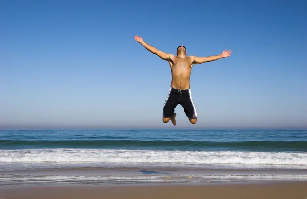 Homem correndo e pulando na praia — Fotografia de Stock