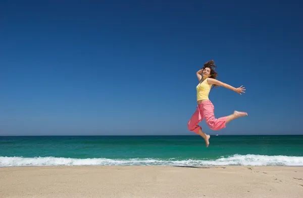 Hermosa mujer saltando en la playa — Foto de Stock