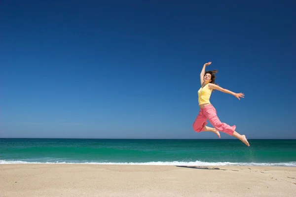 Schöne Frau springt in den Strand — Stockfoto