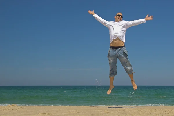 Homme sautant sur la plage — Photo