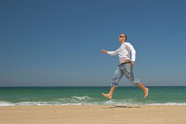 Man springt op het strand — Stockfoto