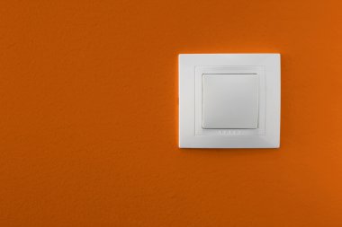 Simple light switch on a orange wall clipart
