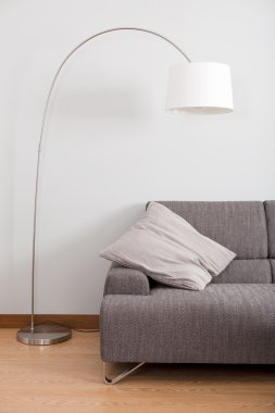 Modern and clean decoration of an apartment with a sofa and a lamp clipart