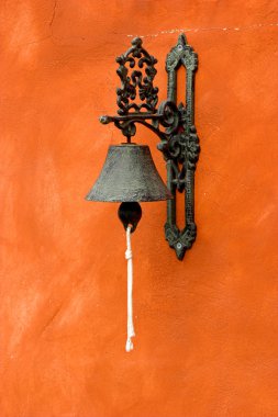 Old vintage bell on a orange wall clipart