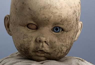 Close-up of baby doll with only on eye opened clipart