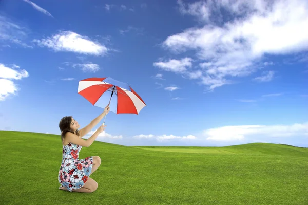 美しい緑の野原に傘とポーズ若く 幸せな女性の肖像画 — ストック写真