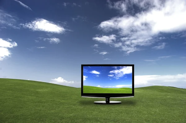現実よりも美しい色を示す緑の草原に現代テレビ — ストック写真