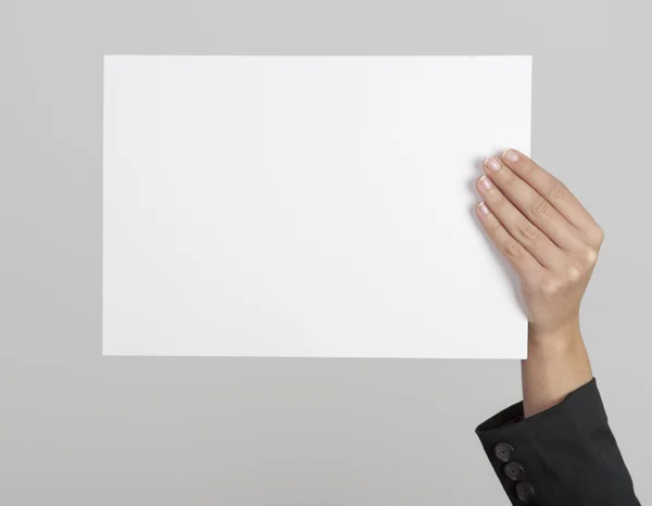 空白の紙のシートを持っている女性の手 — ストック写真