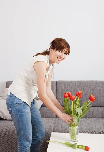 Kadın evde çiçek tutan — Stok fotoğraf