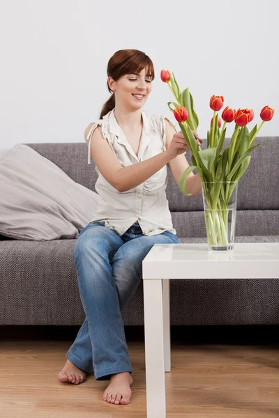 Mujer en casa sosteniendo flores —  Fotos de Stock