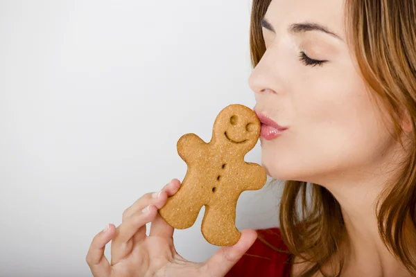 Kissing a gingerbread cookie — Stock Photo, Image