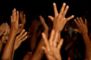 Raised hands on black background clipart