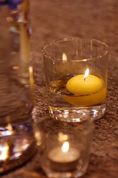 stock image Burning candle in water glass