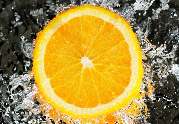 Свежий апельсин в потоковой воде — стоковое фото