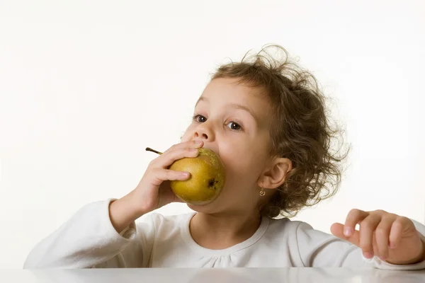Kleines Mädchen isst eine Birne — Stockfoto
