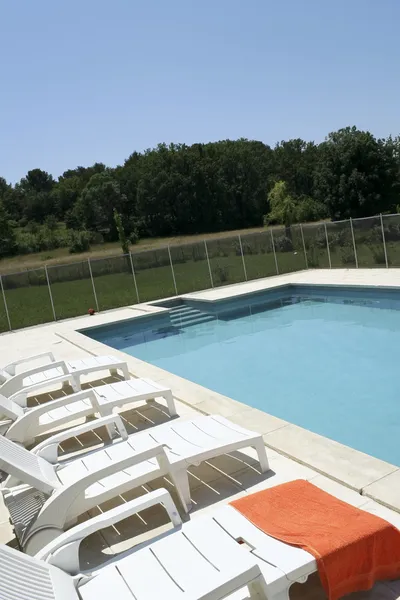 Toalla naranja junto a la piscina — Foto de Stock