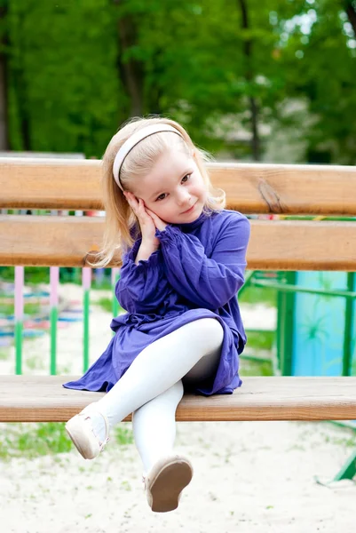 Μικρό κορίτσι σε ένα παγκάκι — Φωτογραφία Αρχείου