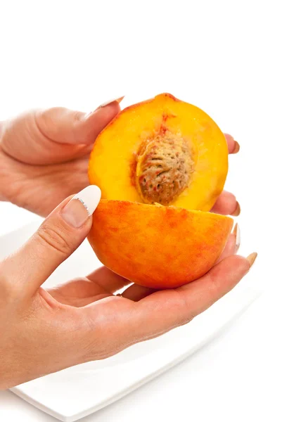 Персик в женских руках — стоковое фото