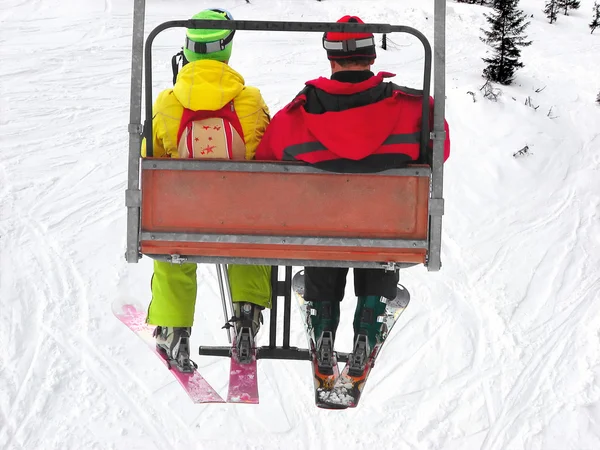 Két síelők a felvonó2 명의 스키 리프트에집의 앞에 판매 부동산 표시 스톡 사진
