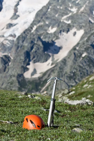 Machado de gelo e capacete no fundo da montanha . — Fotografia de Stock