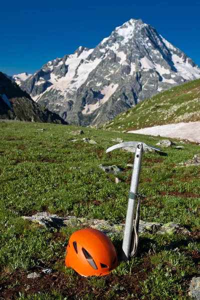Eispickel und Helm auf der Bergkulisse. — Stockfoto