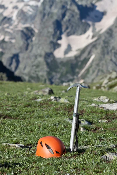 Eispickel und Helm auf der Bergkulisse. — Stockfoto