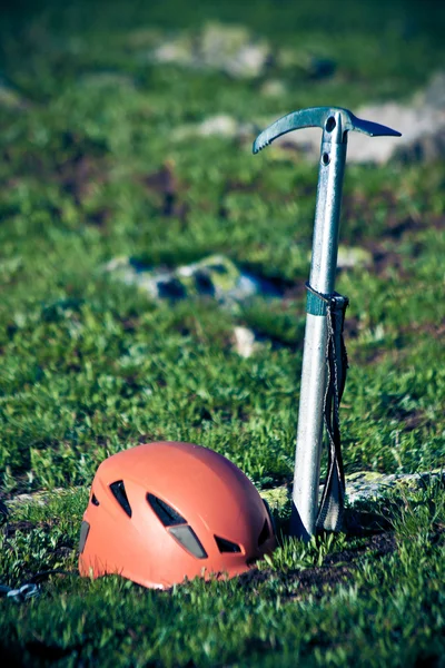 Ijsbijl en helm op de berg achtergrond. — Stockfoto