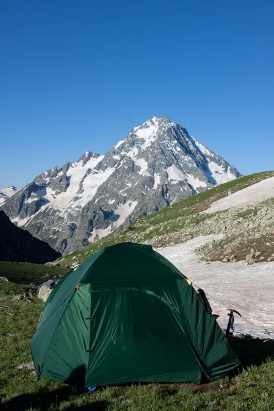 日当たりの良い草地に緑のキャンプ テント. — ストック写真
