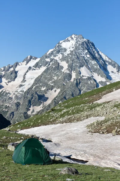 햇볕이 잘 드는 목초지에 녹색 캠핑 텐트. — 스톡 사진