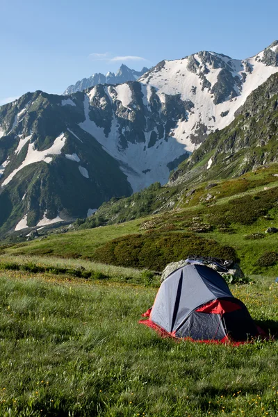 Röd camping tält på soliga gräsmark. — Stockfoto