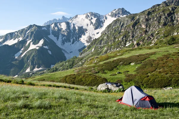 Röd camping tält på soliga gräsmark. — Stockfoto