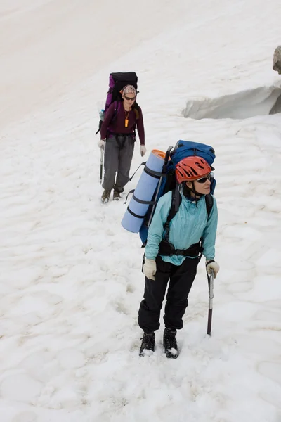Two girls backpackers on snow. — Stock Photo, Image