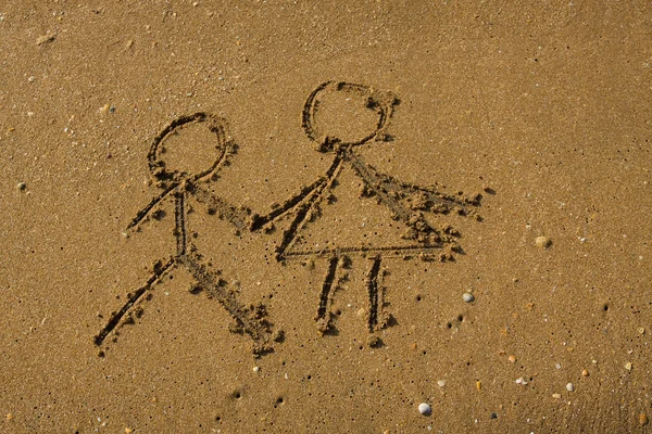 Menina e menino desenhado em uma areia de praia . — Fotografia de Stock