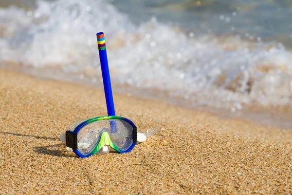 Трубка и маска для подводного плавания на берегу моря с галькой — стоковое фото