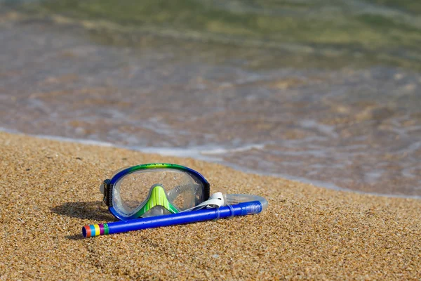 Buis en masker voor een duiken op Zeekust met een kiezelsteen — Stockfoto