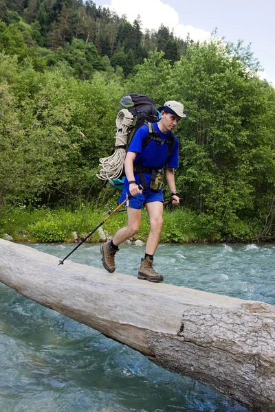 Backpacker crossing the river. — Stock Photo, Image