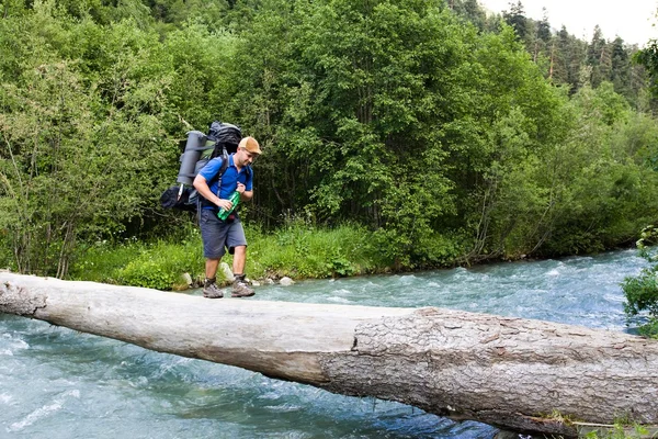Backpacker przeprawa przez rzekę. — Zdjęcie stockowe