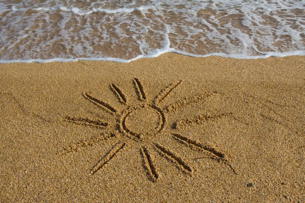 Солнце, нарисованное на песке — стоковое фото