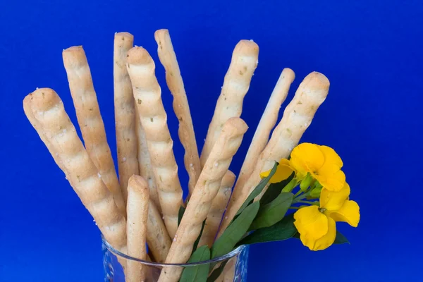 Breadsticks och gul blomma — Stockfoto