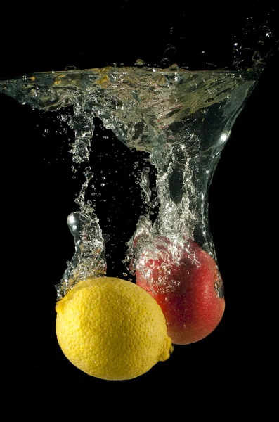 Citron och äpple falla i vatten — Stockfoto